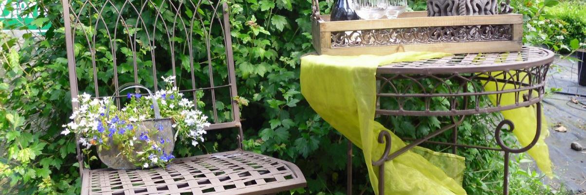 Alte Metallgartensitzgruppe mit Deko